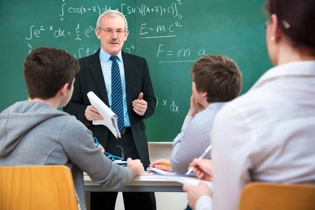A teacher standing and explaining something to students